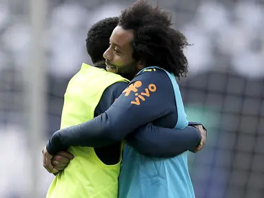 Bek Brasil, Marcelo, memeluk Taison, saat latihan jelang laga persahabatan di Berlin, Jerman, Selasa, (27/3/2018). Brasil akan berhadapan dengan Jerman. (AP/Michael Sohn)