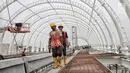 Pekerja menyelesaikan proyek pembangunan Light Rail Transit (LRT) Jabodebek di Stasiun LRT TMII, Jakarta, Senin (14/1). Progres pembangunan Stasiun LRT TMII yang ditargetkan selesai akhir April 2019 sudah mencapai 40%. (Liputan6.com/Faizal Fanani)