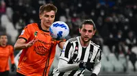 Bek Spezia Salvador Ferrer (kiri) berebut bola dengan gelandang Juventus Adrien Rabiot pada pertandingan Liga Italia pekan ke-28 di Allianz Stadium, Senin (7/3/2022) dini hari WIB. Juventus menang 1-0 atas Spezia lewat gol Alvaro Morata. (MIGUEL MEDINA / AFP)