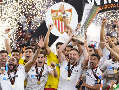 Kapten tim Sevilla Ivan Rakitic (tengah) dan Jesus Navas (tengah kanan) mengangkat trofi setelah memenangkan pertandingan sepak bola final Liga Europa antara Sevilla dan AS Roma di Puskas Arena, Budapest, Hungaria, Rabu (31/5/2023). Sevilla mengalahkan AS Roma 4-1 dalam adu penalti setelah pertandingan berakhir imbang 1-1. (AP Photo/Petr David Josek)