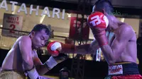 Petinju Indonesia, Ilham Leoisa (kanan) melepaskan pukulan ke wajah petinju Thailand, Paiboon Lorkham pada kelas Super-Lightweight Mahkota Boxing Super Series di Cilandak Town Square, Jakarta (10/3/2018). Ilham menang angka mutlak. (Bola.com/Nick Hanoatub