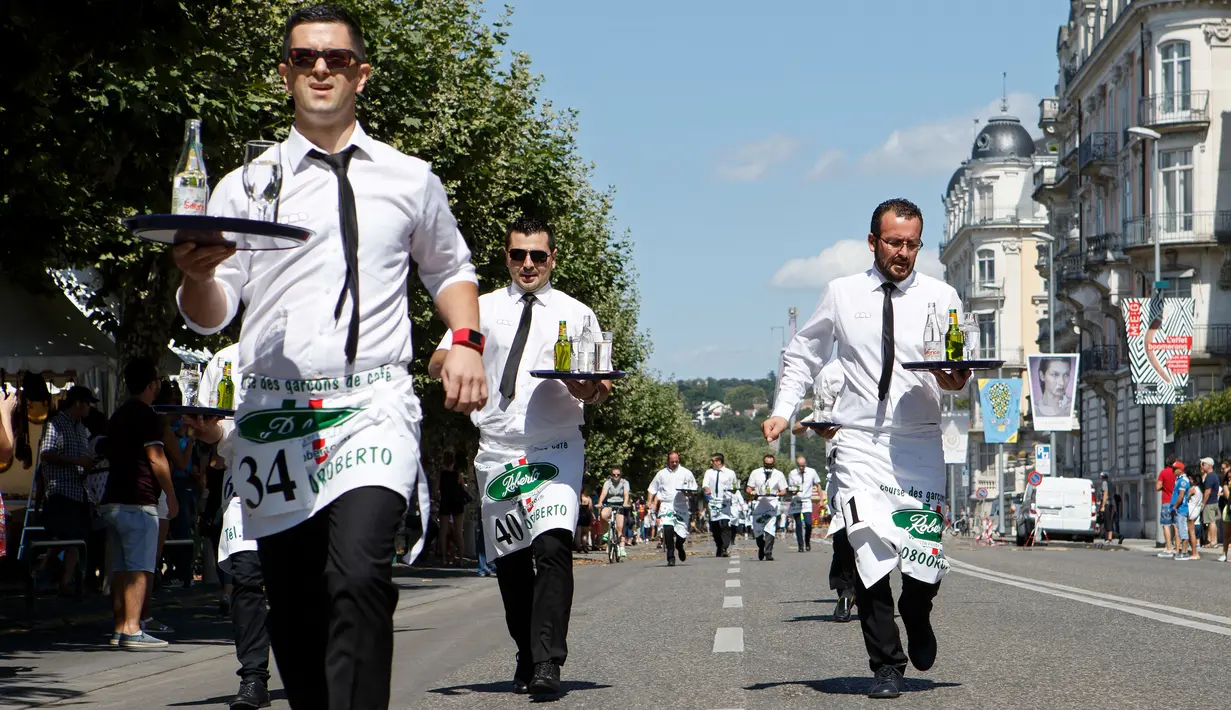 Sejumlah pramusaji beradu ketangkasan dalam Waiters Race ke-21 di Fetes de Geneve, Swiss, 6 Agustus 2017. Peserta diminta unjuk kebolehan menggunakan satu tangan membawa nampan berisi dua gelas dan dua botol penuh air. (Salvatore Di Nolfi/Keystone via AP)