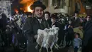 Seorang pria Yahudi ultraortodoks memegang beberapa ekor ayam sebelum melakukan ritual Kapparot di Yerusalem, 12 September 2021. Kapparot adalah ritual transfer dosa ke ayam yang dilakukan sebelum Yom Kippur (Hari Penebusan). (MENAHEM KAHANA/AFP)