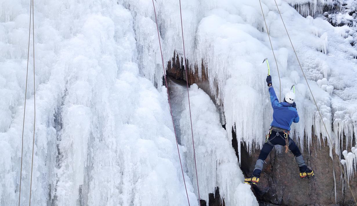 Aksi seorang pria memanjat dinding es buatan di desa Vir, Republik Ceko, Minggu (14/2/2021). Ketika suhu turun di Republik Ceko, pemanjat tebing memanfaatkan kondisi beku dengan mengubah permukaan batu menjadi dinding es setinggi 20 meter untuk pendaki. (AP Photo/Petr David Josek)