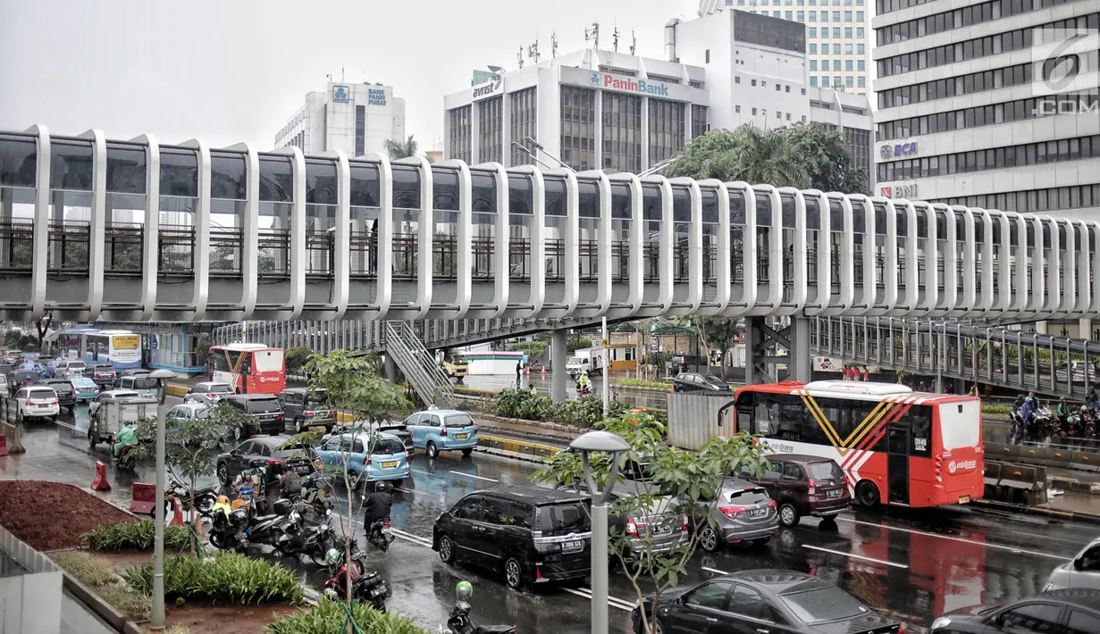 Kondisi lalu di sekitar jembatan penyeberangan orang (JPO) Bundaran Senayan, Jakarta, Senin (21/1). JPO Bundaran Senayan sudah terhubung dengan Halte Transjakarta dan siap untuk dioperasikan. (Liputan6.com/Faizal Fanani)