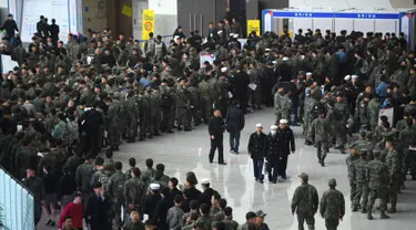 Tentara Korea Selatan mengantre saat mengikuti job fair di ruang pameran KINTEX, Goyang, Korea Selatan, Rabu (20/3). Para tentara yang mengikuti job fair ini adalah mereka yang akan diberhentikan dalam waktu dekat. (JUNG Yeon-Je/AFP)