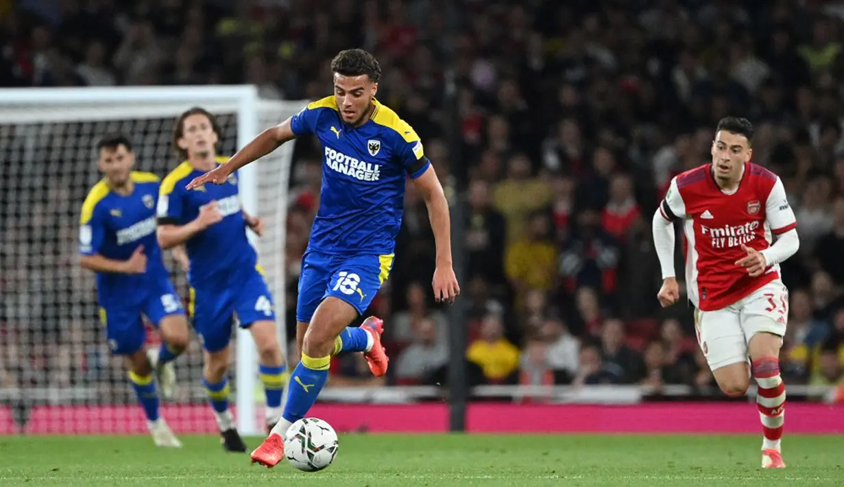 Pemain AFC Wimbledon Nesta Guinness-Walker (tengah) mengontrol bola saat melawan Arsenal pada pertandingan Piala Liga Inggris di Emirates Stadium, London, Inggris, 22 September 2021. Arsenal menang 3-0. (JUSTIN TALLIS/AFP)