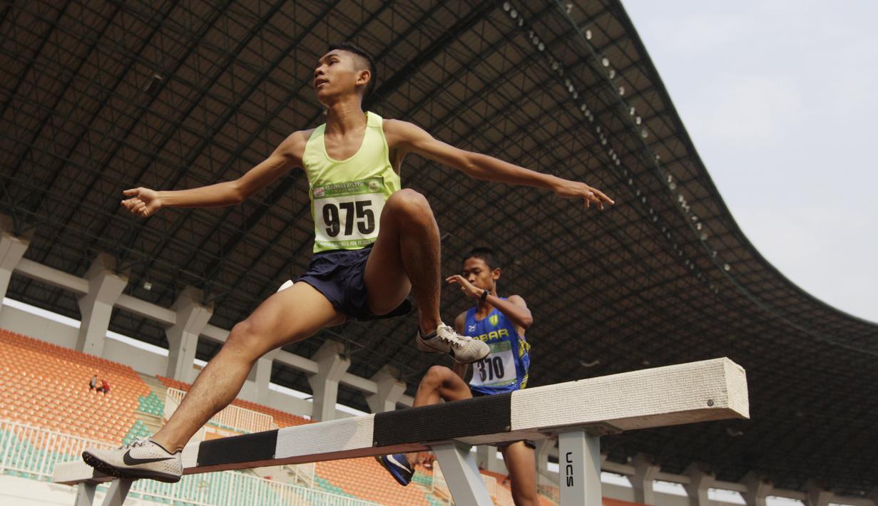 Pelari Sumatra Utara, Loudry Rafael, melakukan lompatan saat Kejurnas Atletik nomor lari 2.000 meter steeplechase putra di Stadion Pakansari, Bogor, Selasa (6/8). Kejurnas tahun ini juga dilakukan untuk kualifikasi jelang PON. (Bola.com/Vitalis Yogi Trisna)