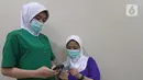 Tenaga kesehatan mengecek pesan singkat penerima vaksin COVID-19 di RSIA Tambak, Jakarta, Selasa (5/01/2021). Kementerian Kesehatan mengirimkan Short Message Service (SMS) blast secara serentak kepada penerima vaksin COVID-19 tahap pertama pada Kamis (31/12) lalu. (Liputan6.com/Herman Zakharia)