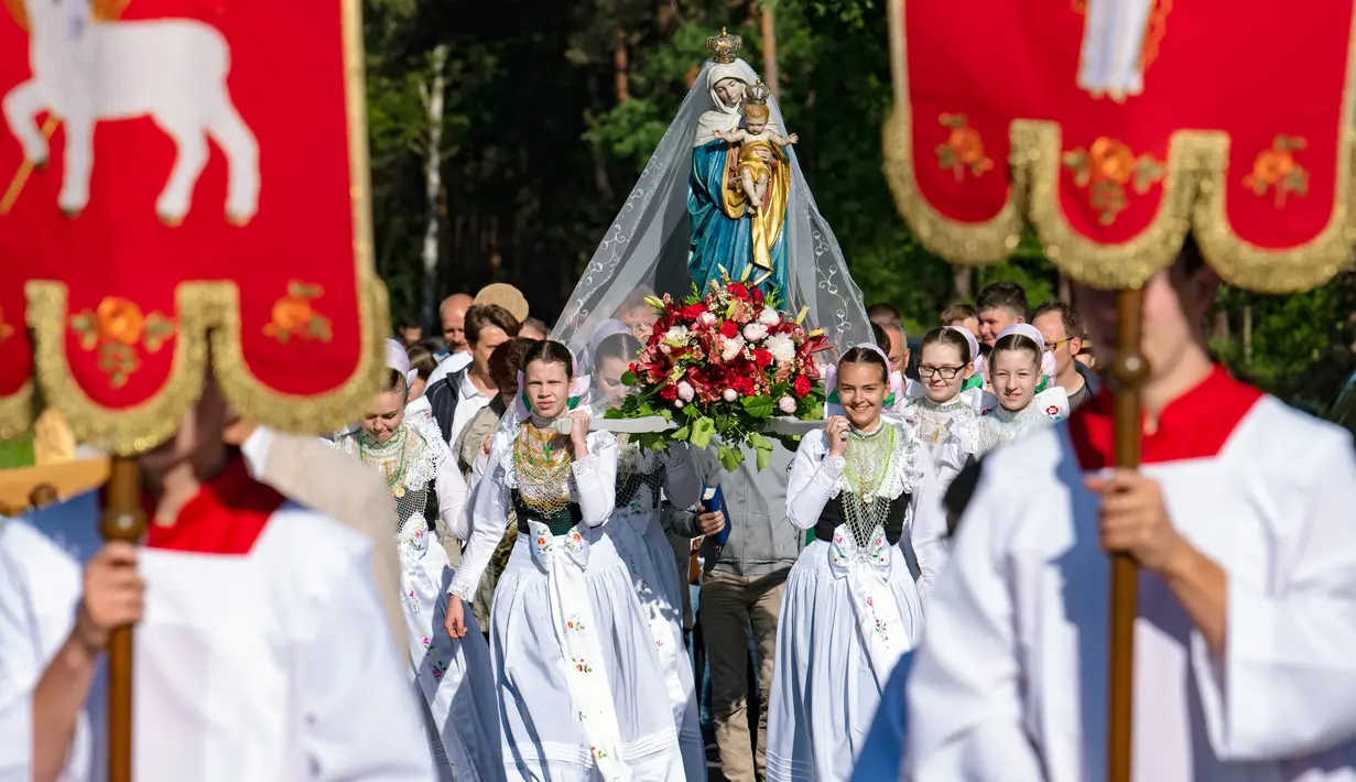 Sejumlah remaja wanita mengenakan pakaian tradisional Sorbs memikul patung Bunda Maria saat mengikuti prosesi Whit Monday di gereja di Rosenthal, Jerman (21/5). Prosesi ini digelar usai tujuh minggu dari perayaan Paskah. (AP Photo / Jens Meyer)