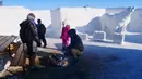 Pengunjung menghangatkan diri di tengah api unggun dalam labirin salju terbesar di dunia, di St. Adolphe, Kanada, 2 Maret 2019. Labirin salju kreasi pasangan suami istri, Clint dan Angie Masse itu memiliki dinding setinggi 1,8 meter (Thibault JOURDAN/AFP)