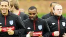 Bek Inggris Rio Ferdinand (kiri) tersenyum saat mengikuti sesi latihan timnas di kamp latihan di London Colney 8 Oktober 2010 jelang laga lawan Montenegro. AFP PHOTO / GLYN KIRK 