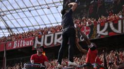 Pelatih Bayer Leverkusen, Xabi Alonso memimpin chant di depan para fans setelah laga lanjutan Liga Jerman 2024/2025 melawan Borussia Dortmund di BayArena, Leverkusen, Jerman, Minggu (11/05/2025) waktu setempat. (AFP/Ina Fassbender)