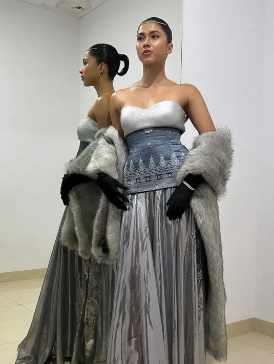 Aghniny Haque hadir dengan gaun silver dari Yosafat memiliki model strapless dipadukan obi songket dan rok panjang flowy. Ditambah dengan syal berbulu warna senada. [@imeldaimew]