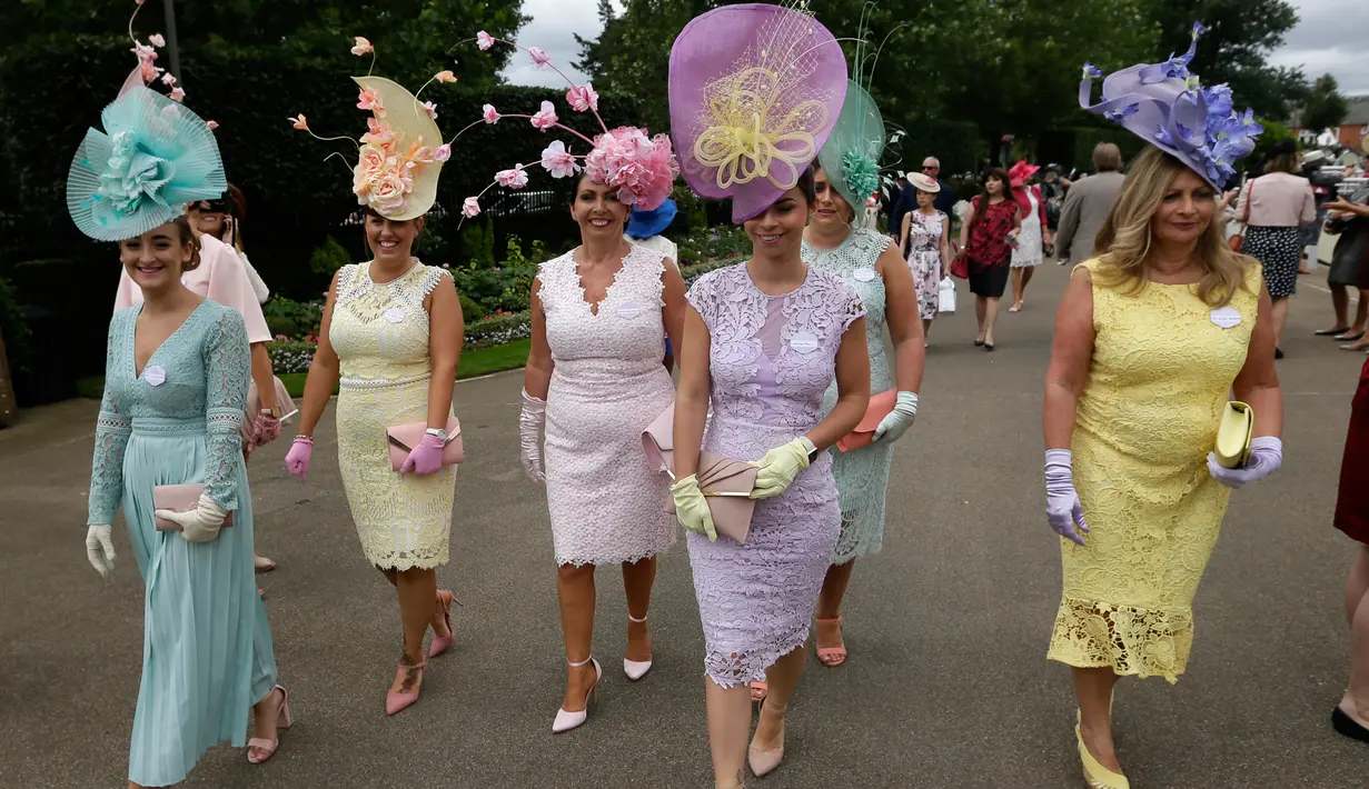 Racegoers dengan hiasan kepala tiba pada hari pertama ajang pacuan kuda Royal Ascot di Inggris, Selasa (19/6). Di acara ini para bangsawan wanita memakai topi dengan desain unik untuk meramaikan acara yang telah diadakan sejak 1711. (AP/Tim Ireland)