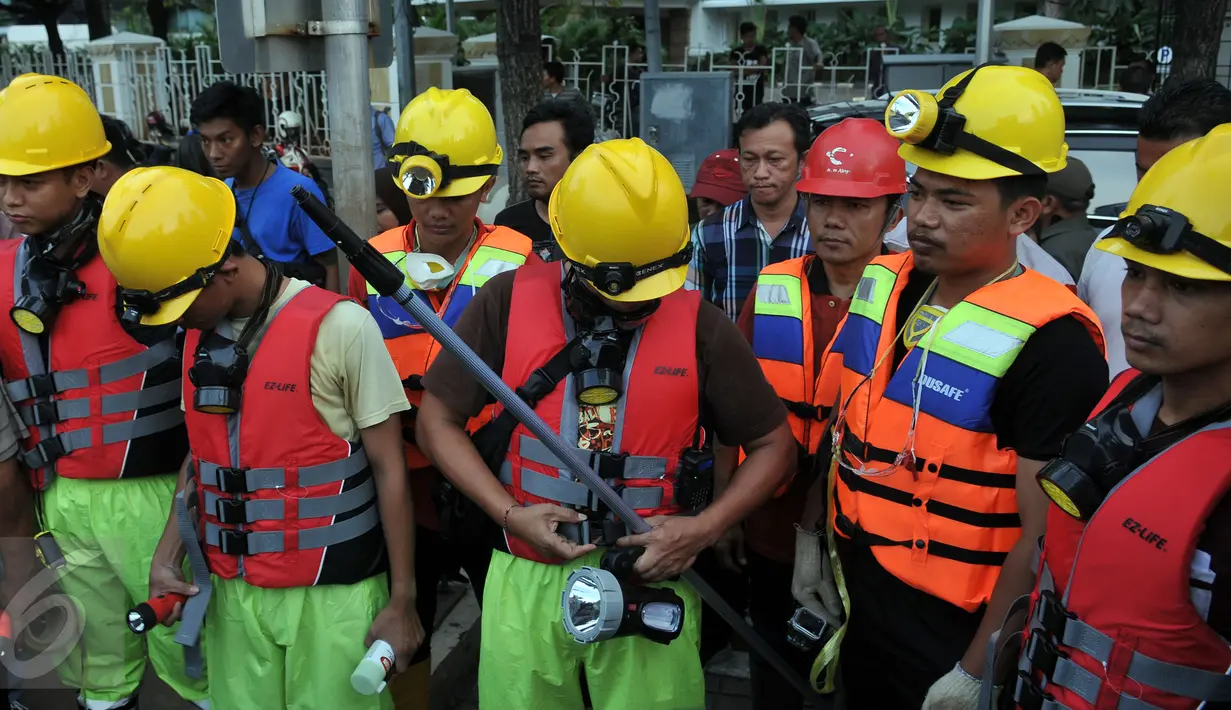 Petugas bersiap melakukan olah TKP di gorong-gorong Jalan Medan Merdeka Selatan, Jakarta, Sabtu (5/3/2016). Di gorong-gorong tersebut petugas menemukan sisa kulit kabel yang diduga menjadi penyebab banjir. (Liputan6.com/Johan Tallo)