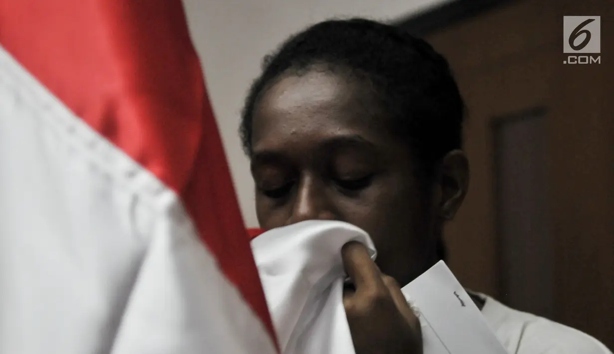 Calon Paskibraka mencium bendera Merah Putih usai mengikuti renungan jiwa di Aula PPPON Cibubur, Jakarta, Minggu (13/8). Malam renungan jiwa sebagai sarana instropeksi diri selama mengikuti pendidikan dan pelatihan. (Liputan6.com/Yoppy Renato)