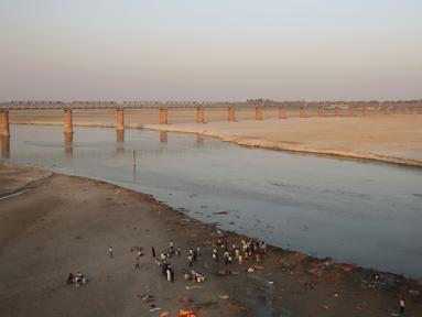 Sejumlah orang berdiri di tepi Sungai Gangga di Allahabad, India, Selasa (21/3). Pengadilan di India utara memberikan hak hukum yang sama sebagai manusia untuk dua sungai yang disucikan umat Hindu, yakni Gangga dan Yamuna. (AP Photo/Rajesh Kumar Singh)