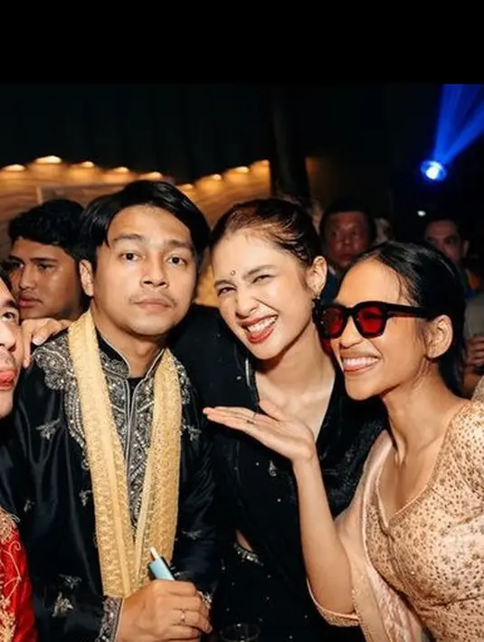 Mikha Tambayong hadir mengenakan busana Bollywood warna hitam, serasi dengan sang suami Deva Mahenra yang dibalut busana hitam berbordir lengkap dengan syal emas. [@taskyanamnya]