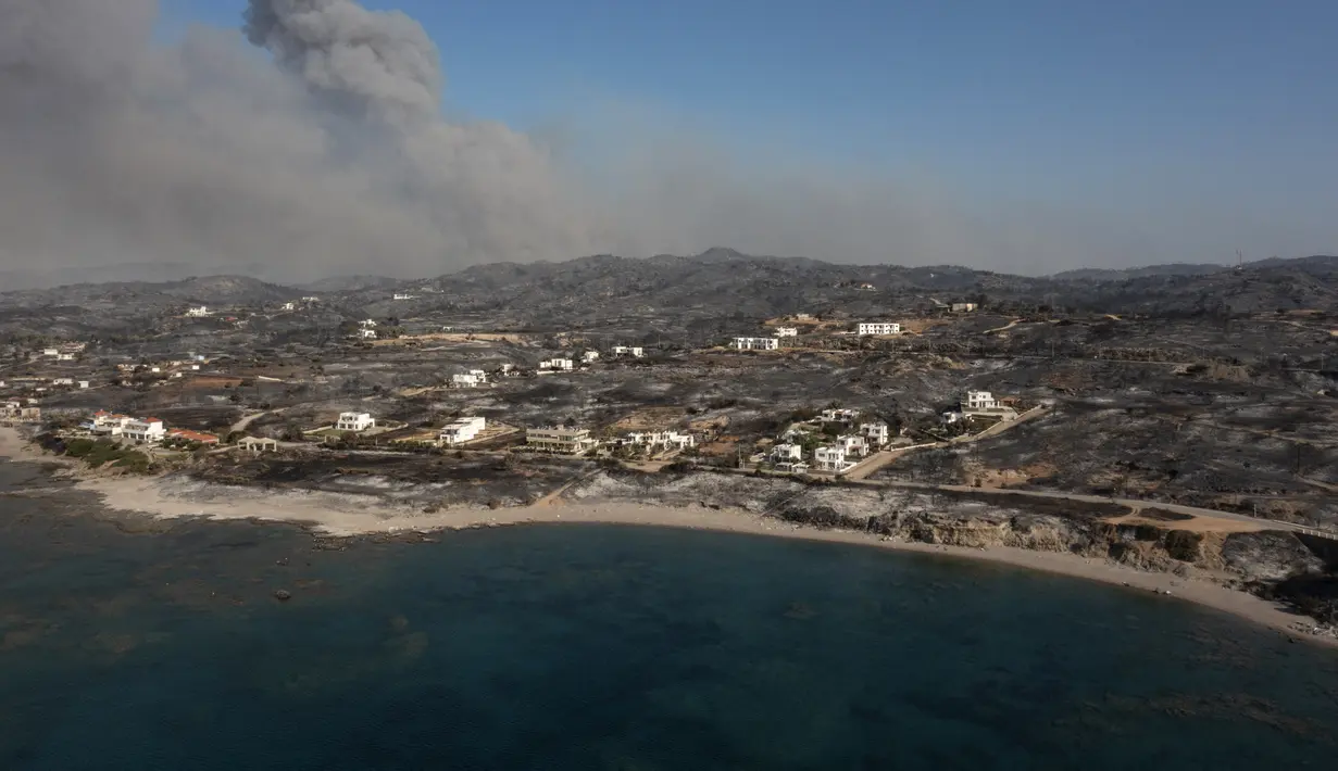 Pemandangan udara menunjukkan asap mengepul di latar belakang desa Kiotari, di pulau Rhodes pada 24 Juli 2023. (AFP/Spyros Bakalis)