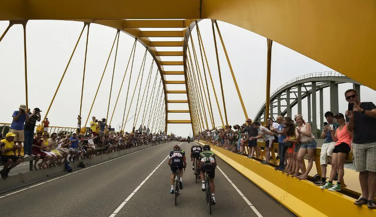 Para pebalap sedang melewati sebuah jembatan di Etape 2 Tour de France yang berjarak 166 km antara Utrecht dan Vrouwenpolder, Belanda. (5/7/2015). (AFP PHOTO/LIONEL BONAVENTURE)