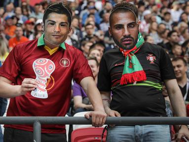 Seorang suporter Portugal memakai topeng berupa wajah Cristiano Ronaldo saat laga Grup A Piala Konfederasi melawan Meksiko di Stadion Kazan Arena, Kazan, Minggu (18/6/2017). (EPA/Mario Cruz)