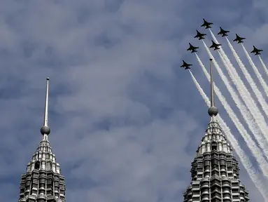 Tim Aerobatik angkatan udara Korea Selatan "Black Eagles" melintasi  menara kembar Petronas dalam Pameran Maritim dan Dirgantara Langkawi Internasional (LIMA) di Kuala Lumpur, Malaysia (29/3). (AFP Photo / Manan Vatsyayana)