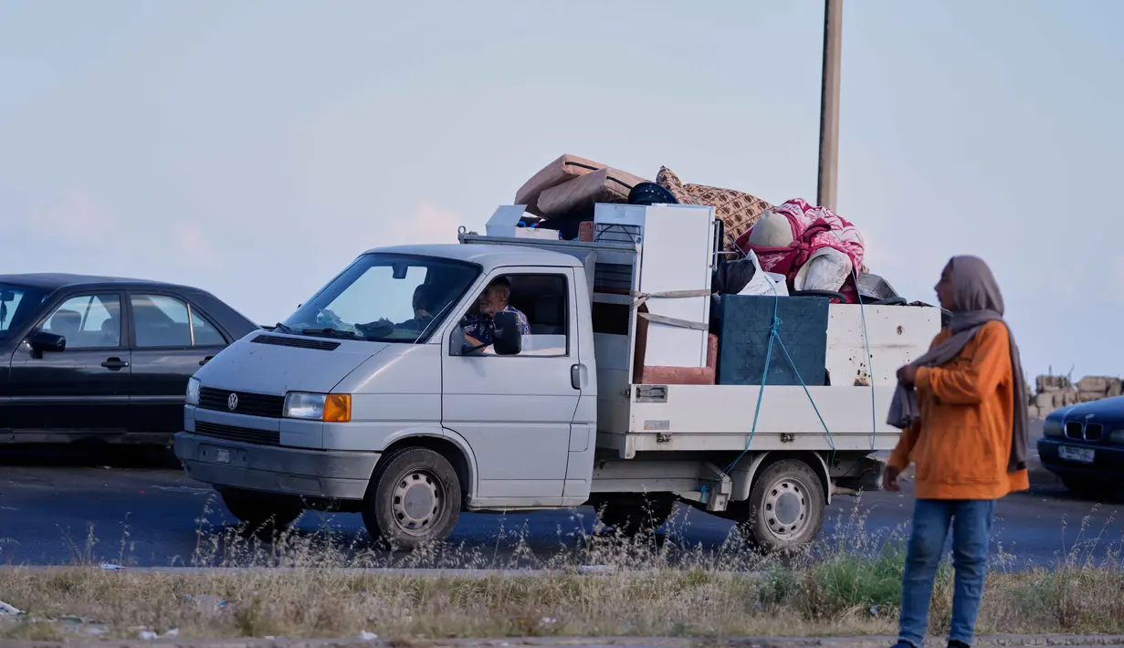 Sebuah keluarga pengungsi dengan barang-barang mereka di dalam sebuah truk untuk kembali ke desa mereka setelah pengumuman kesepakatan gencatan senjata awal antara Amerika Serikat dan Iran, di kota pelabuhan selatan Sidon, Lebanon, Senin 15 Juni 2026. (AP Photo/Mohammed Zaatari)