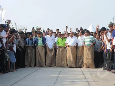 Terpilih menjadi Presiden dalam Pilpres kemarin tidak membuat Jokowi  gengsi saat didaulat ikut lomba balap karung (Liputan6.com/Herman   Zakharia)