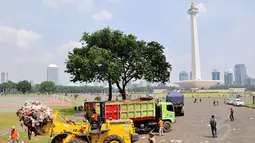 Beberapa truk dikerahkan untuk mengangkuti sampah yang mulai menggunung di kawasan Monumen Nasional, Jakarta, (31/7/2014). (Liputan6.com/Faizal Fanani)
