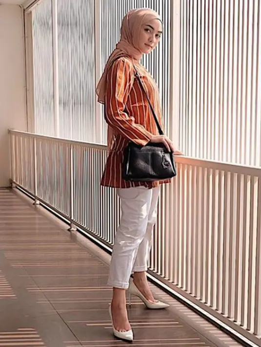 Ciki juga menyukai outfit dengan warna cerah seperti kemeja orange yang dipadukan dengan hijab krem, tas hitam, celana dan heels berwarna putih. (Liputan6.com/IG/@citraciki)