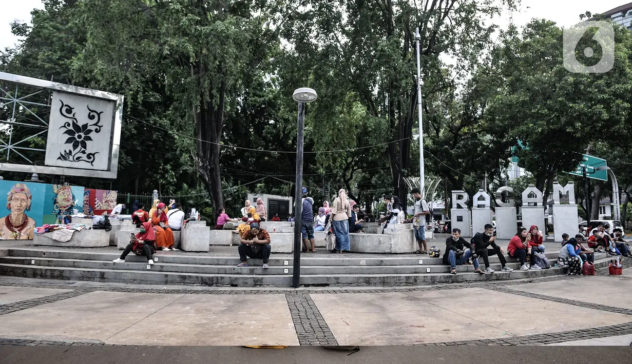 Warga menikmati sore hari di depan gerbang masuk Monumen Nasional (Monas), Jakarta, Minggu (15/11/2020). Meski masih ditutup untuk umum sejak awal pandemi Covid-19, kawasan Monas tetap ramai dikunjungi warga untuk sekadar mengisi akhir pekan. (merdeka.com/Iqbal S Nugroho)