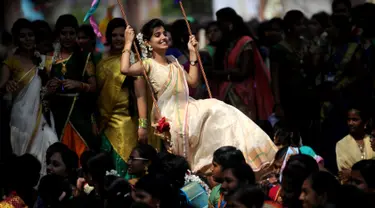 Wanita India bermain ayunan saat festival panen Tamil di perguruan tinggi di Chennai, India (11/1).  Perayaan ini sebagai simbol terima kasih warga kepada alam yang telah memberi hasil panen yang melimpah. (AFP Photo/Arun Sankar)