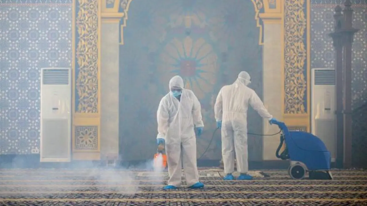 Pekerja mengenakan APD melakukan semprotan desinfektan di sebuah masjid di Bandar Seri Begawan, Brunei. (AFP)