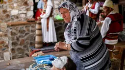 Wanita Kosovo, Sheqerie Buqaj saat menerima lukisan wajah tradisional di Desa Kukaj, Kosovo, Rabu (5/9). Tradisi melukis wajah untuk pengantin wanita ini sudah ada sejak berabad-abad silam. (ARMEND NIMANI/AFP)