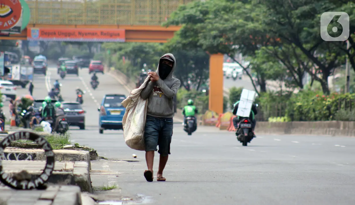 Pemulung berjalan di Jalan Margonda Raya, Depok, Kamis (16/4/2020). Pandemi COVID-19 memberikan dampak yang sangat besar bagi sosial dan ekonomi Indonesia. Bahkan yang paling dikhawatirkan bertambahnya angka kemiskinan dan pengangguran. (Liputan6.com/Helmi Fithriansyah)