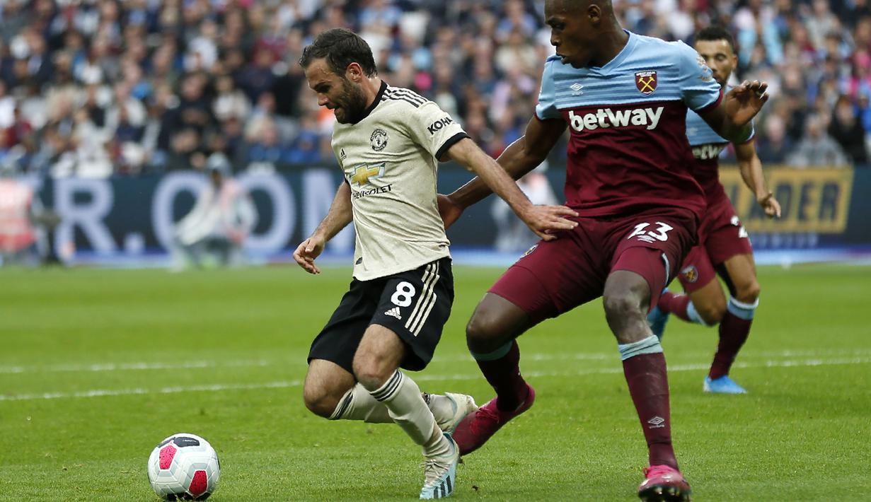 Gelandang Manchester United, Juan Mata, berusaha melewati bek West Ham, Issa Diop, pada laga Premier League di Stadion London, London, Minggu (22/9). West Ham menang 2-0 atas MU. (AFP/Ian Kington)