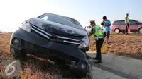 Petugas kepolisian memeriksa kendaraan yang mengalami kecelakaan di Tol Cipali, Jawa Barat, Senin (13/7/2015). Mobil bernomor polisi D 1807 PB tersebut menabrak penanda jalan di Km 149+800. (Liputan6.com/Herman Zakharia)