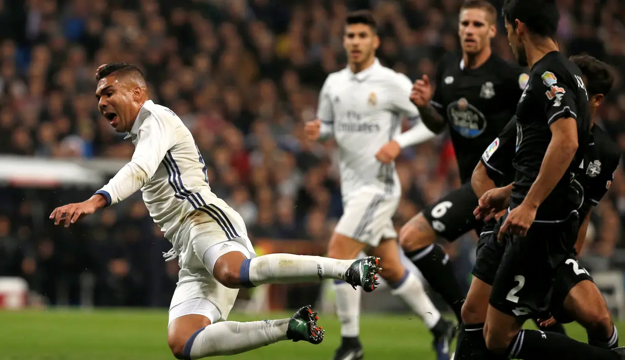 Pemain Real Madrid, Casemiro (kiri) terjatuh saat laga melawan Deportivo La Coruna di Santiago Bernabeu, Minggu (11/12). Menang 3-2, Madrid kini sudah membukukan 35 pertandingan berturut-turut tanpa kekalahan. (REUTERS / Javier Barbancho)
