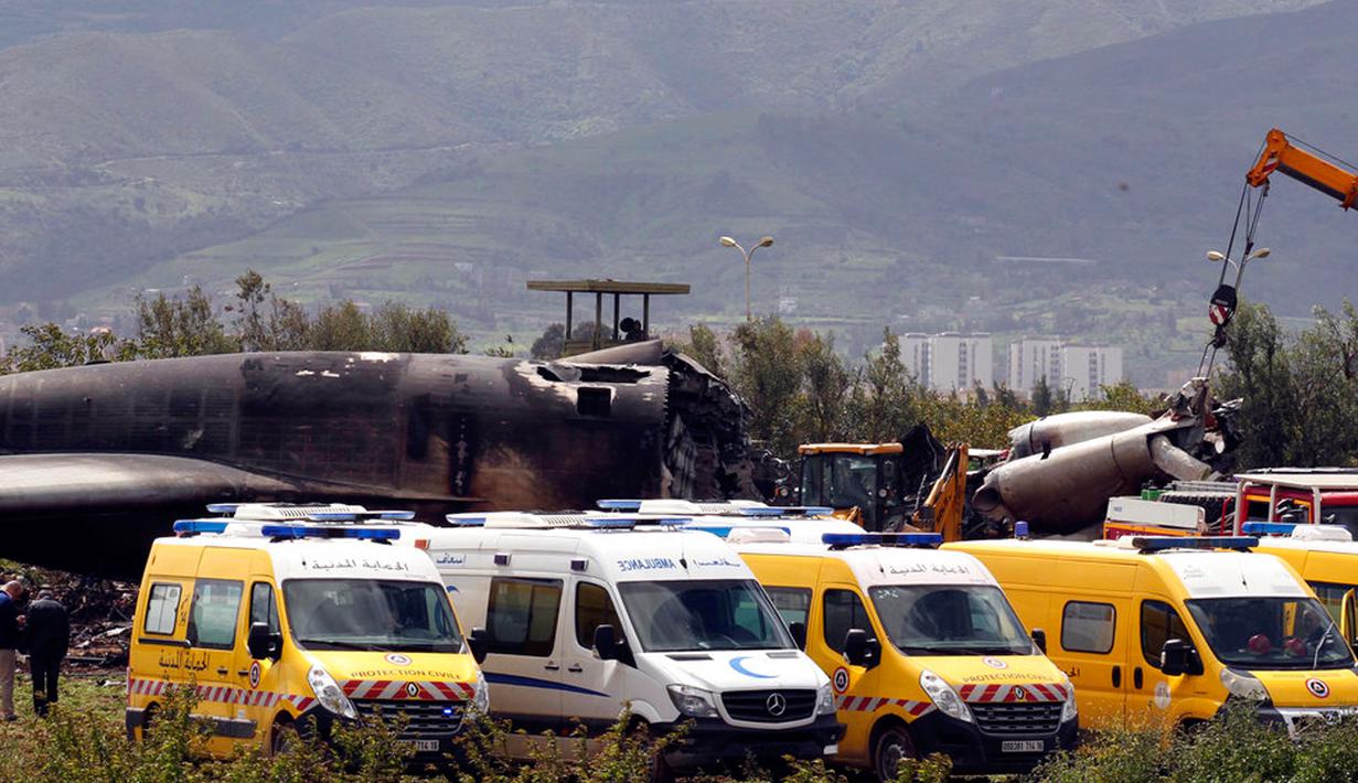 Tim medis bersama petugas kebakaran mencari korban di reruntuhan pesawat tentara Aljazair yang jatuh di dekat pangkalan udara Boufarik, Aljazair (11/4). Sebagian besar korban adalah personel militer dan keluarga mereka. (AP Photo/Anis Belghoul)