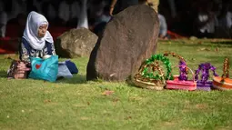 Seorang wanita berdoa saat ziarah di Kuburan Massal Ulee Lheue selama peringatan 14 tahun tsunami Aceh di Banda Aceh, Rabu (26/12). Sejumlah warga mengenang keluarga yang meninggal akibat bencana tsunami di Aceh 14 tahun silam. (Chaideer MAHYUDDIN / AFP)