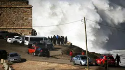 Warga berkumpul untuk menonton pertunjukan para peselancar dunia di Praia do Norte, Nazare,Portugal, (19/2/16). Peselancar asal Amerika Garrett McNamara pernah menakhlukan ombak setinggi 23.77 Meter. (REUTERS/Rafael Marchante)