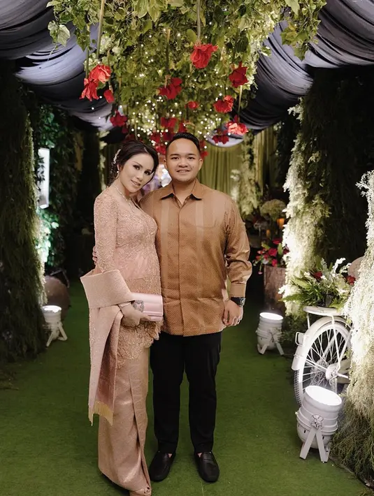Sebagai seorang istri, Momo selalu menemani sang suami. Kali ini ia datang kondangan bersama suaminya. Momo Geisha mengenakan kebaya berwarna nude, sedangkan Nicola Reza Samudra memakai kemeja berwarna coklat. Keduanya pun tampak begitu serasi. (Liputan6.com/IG/@therealmomogeisha)