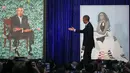 Presiden AS ke-44 Barack Obama menujuk lukisan dirinya saat upacara peresmian di Galeri Potret Nasional Smithsonian, Washington DC (12/2). (Mark Wilson/Getty Images/AFP)