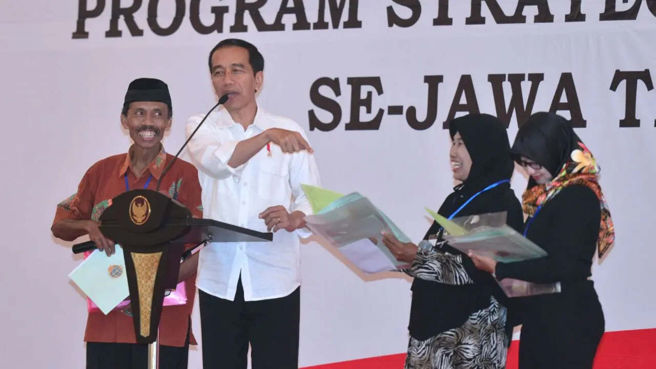 Jokowi menyerahkan sertifikat hak atas tanah program strategis nasional di Gedung New Sari Utama Convention Hall, Jember.