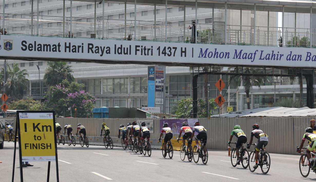 Para pebalap melintasi jembatan penyebrangan dengan jarak 1km sebelum garis finish pada ajang Tour de Jakarta di Jakarta, Sabtu (30/7/2016). (Bola.com/Nicklas Hanoatubun)