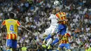 Pemain Real Madrid, Karim Benzema (kiri) atas) menyundul bola saat duel dengan pemain Valencia, Ruben Vezo pada lanjutan La Liga Spanyol di Santiago Bernabeu stadium, Madrid, (27/8/2017). Real ditahan Imbang 2-2. (AP/Francisco Seco)