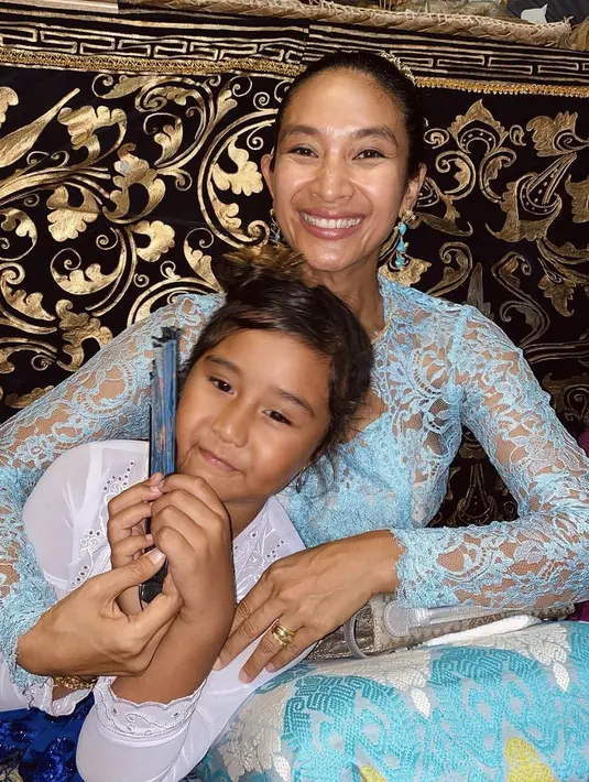 Tinggal di Bali, Happy dan si kecil mengenakan kebaya khas Bali. Happy dengan kebaya biru sedangkan Kinandari mengenakan kebaya putih.  @happysalma