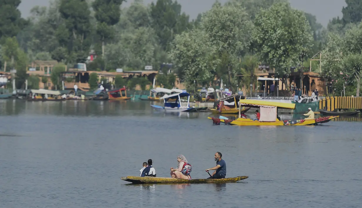 <p>Seorang pria mendayung perahu selama jam sekolah di Danau Dal di Srinagar, India, Rabu (11/5/2022). Danau terbesar di negara bagian tersebut penting untuk kegiatan perikanan, perairan, rekreasi, dan pariwisata. (TAUSEEF MUSTAFA / AFP)</p>