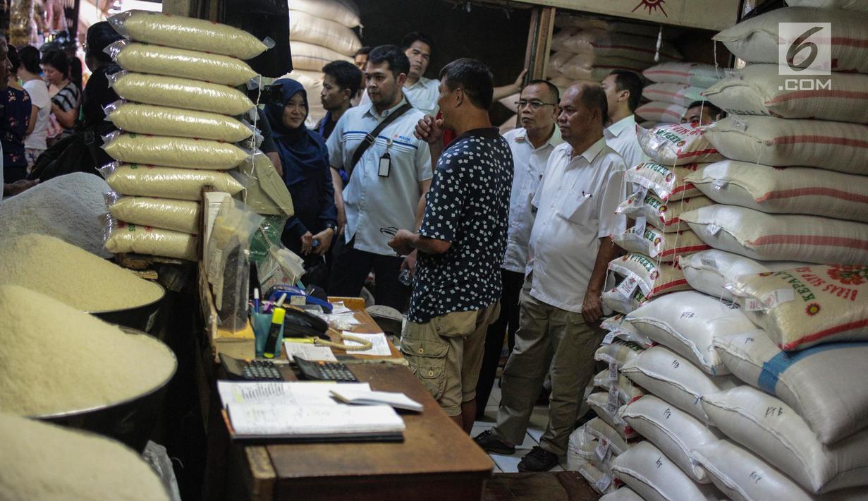 Tim Satgas Pangan Polda Metro Jaya dan Perum Bulog berbincang dengan pedagang saat meninjau harga beras di Pasar Tomang Barat, Jakarta, Rabu (21/11). Kegiatan tersebut untuk memantau stabilitas harga beras medium di pasaran. (Liputan6.com/Faizal Fanani)